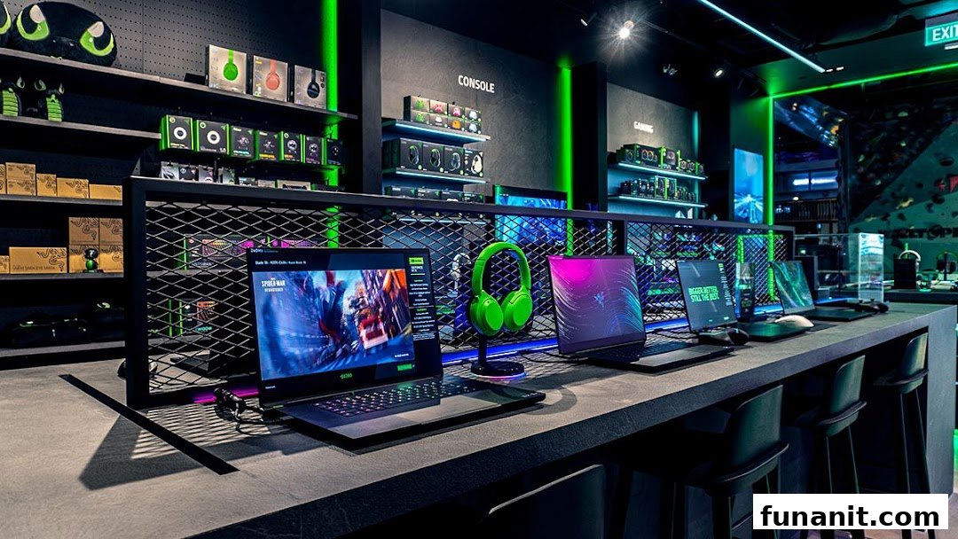 Interior view of RazerStore Funan showcasing gaming laptops, peripherals, and accessories in a sleek, dark setting with green lighting.