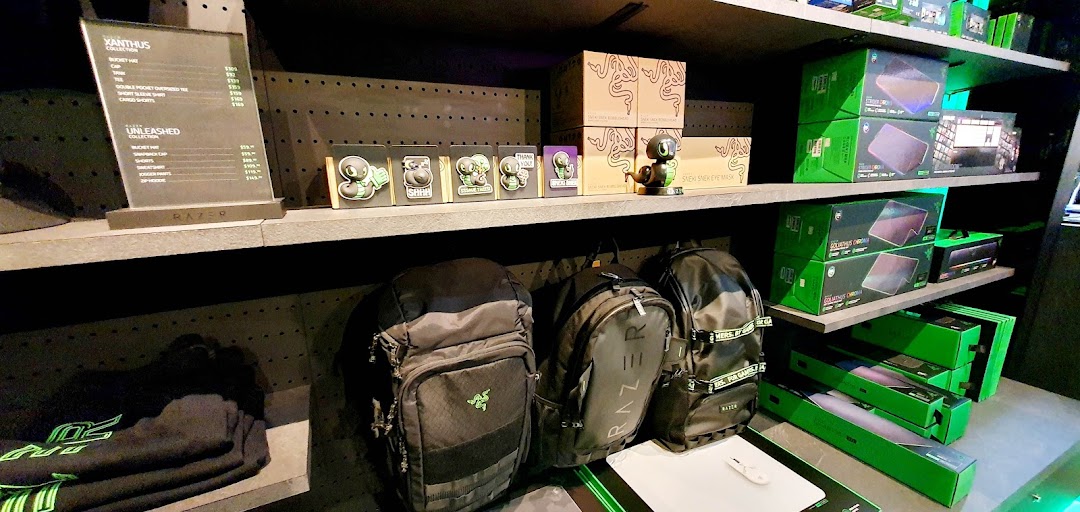 Interior view of RazerStore displaying gaming gear, apparel, and collectibles on shelves.