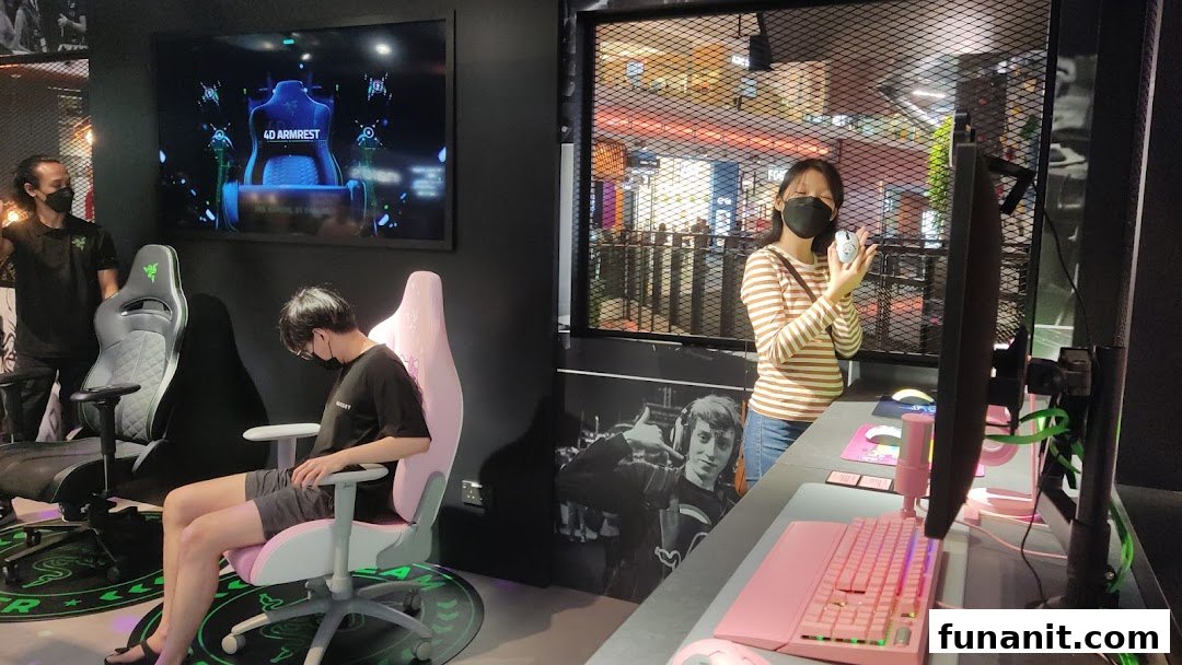 Customers interact with gaming chairs and peripherals in the RazerStore, showcasing products and an immersive experience.