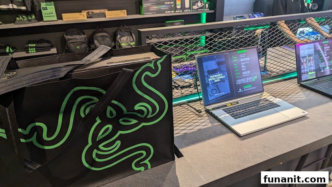 Interior view of RazerStore Funan showcasing gaming laptops, merchandise, and a branded tote bag.