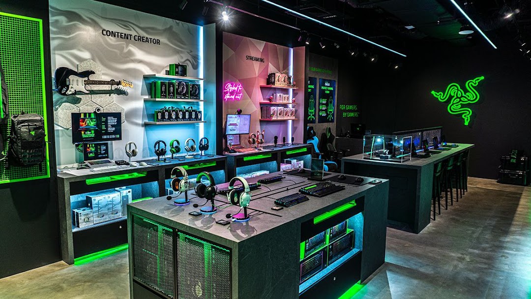 A vibrant interior view of RazerStore Funan, showcasing gaming peripherals, setups, and green lighting.