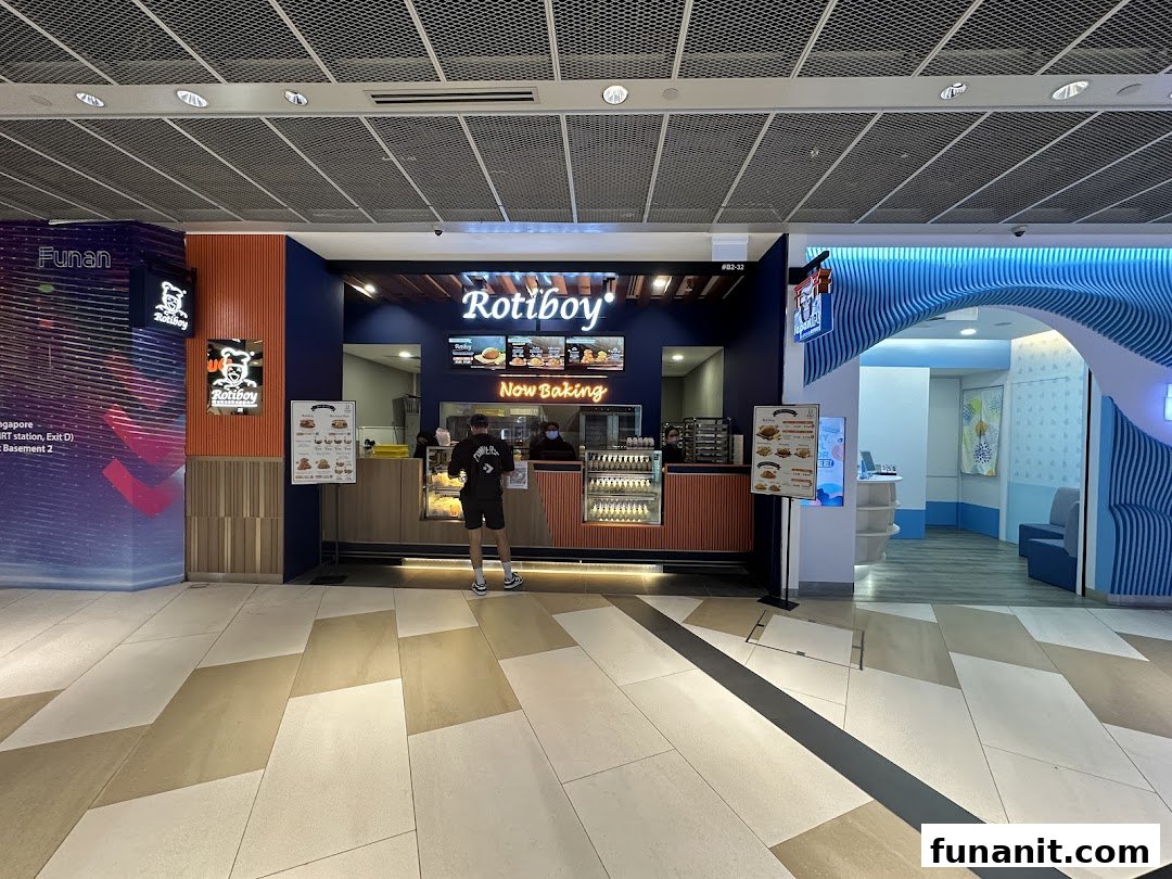 The Rotiboy shop front in a mall, featuring its signature branding and a customer at the counter.