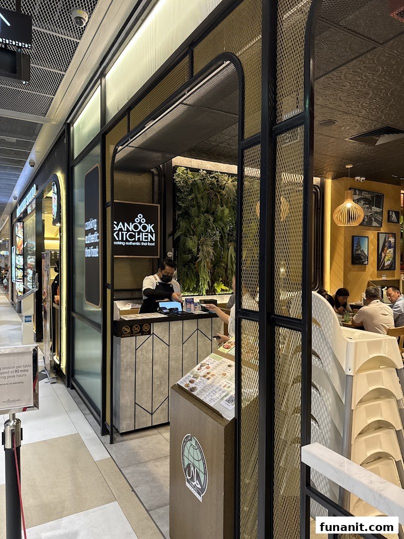 The inviting entrance of Sanook Kitchen at Funan Mall, showcasing its modern design and a glimpse of the dining area.