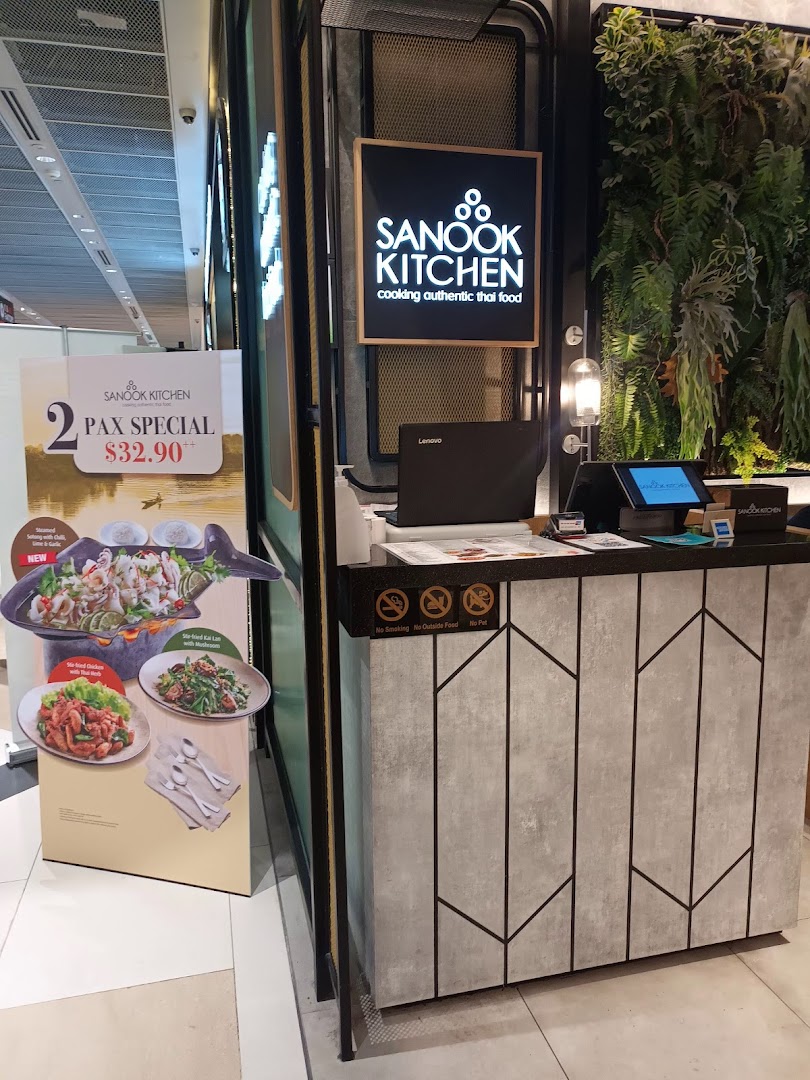 The shop front of Sanook Kitchen, featuring its logo, a promotional stand, and a modern counter.