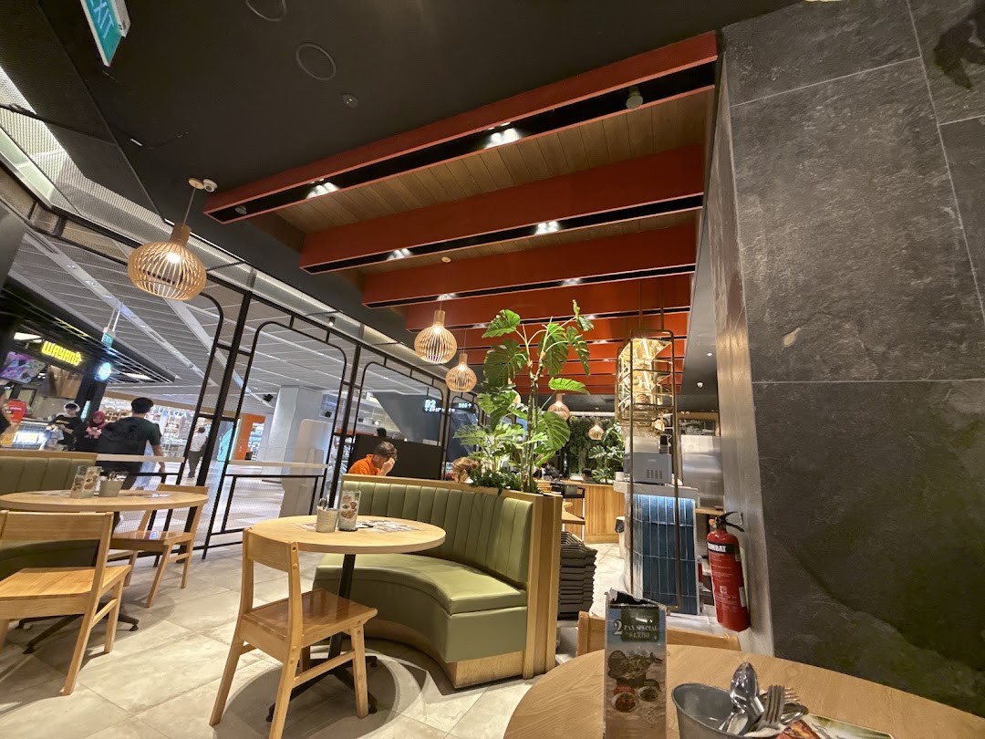 An inviting interior shot of Sanook Kitchen, featuring comfortable seating, modern decor, and a view of the mall.