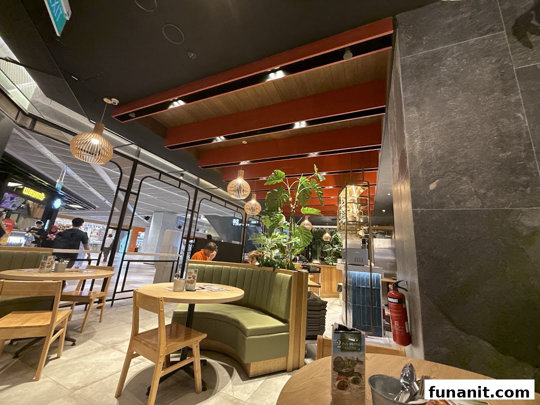 An inviting interior shot of Sanook Kitchen, featuring comfortable seating, modern decor, and a view of the mall.