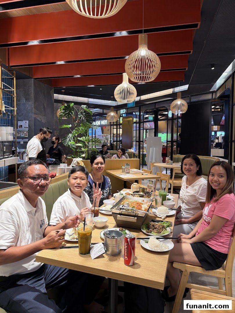 A group of diners enjoying a meal together at Sanook Kitchen, featuring a hotpot and various dishes.