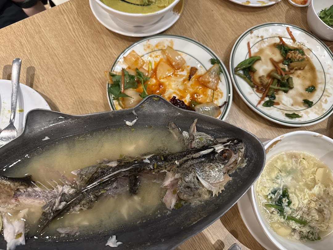 A table showcasing the delicious aftermath of a Thai meal, with partially eaten dishes and a fish skeleton.
