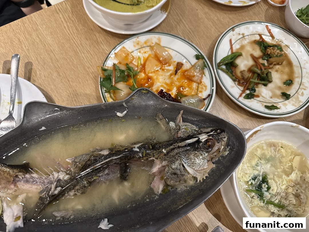 A table showcasing the delicious aftermath of a Thai meal, with partially eaten dishes and a fish skeleton.