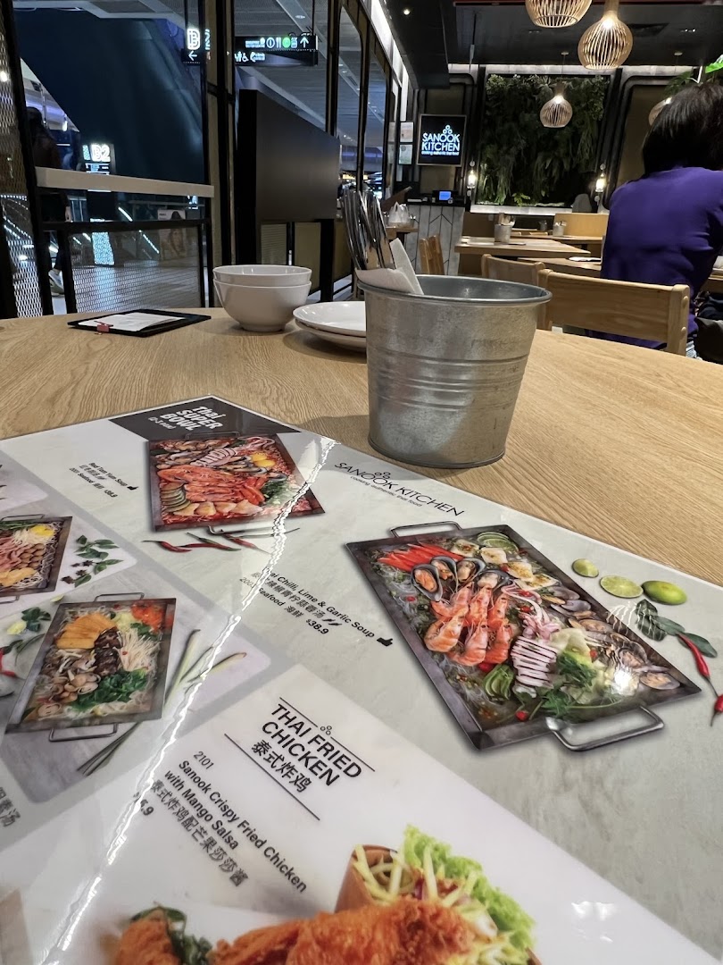 A close-up of Sanook Kitchen's menu displaying Thai dishes like fried chicken and seafood platters.