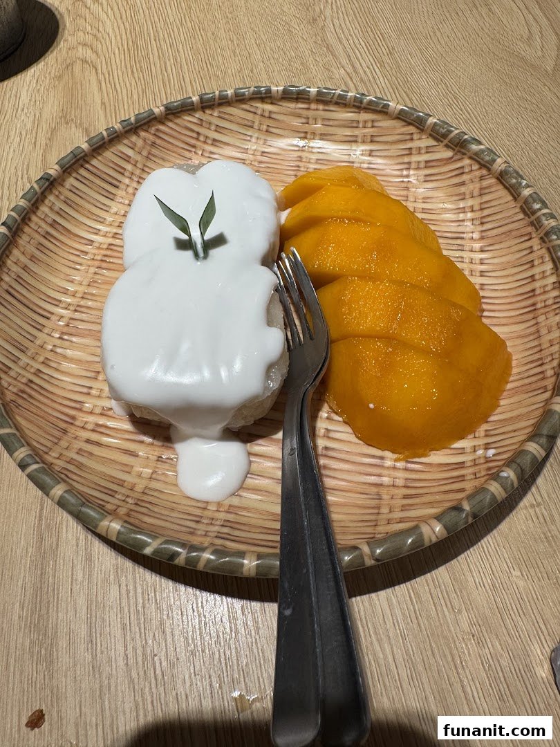 A delicious plate of mango sticky rice with coconut cream and fresh mango slices.
