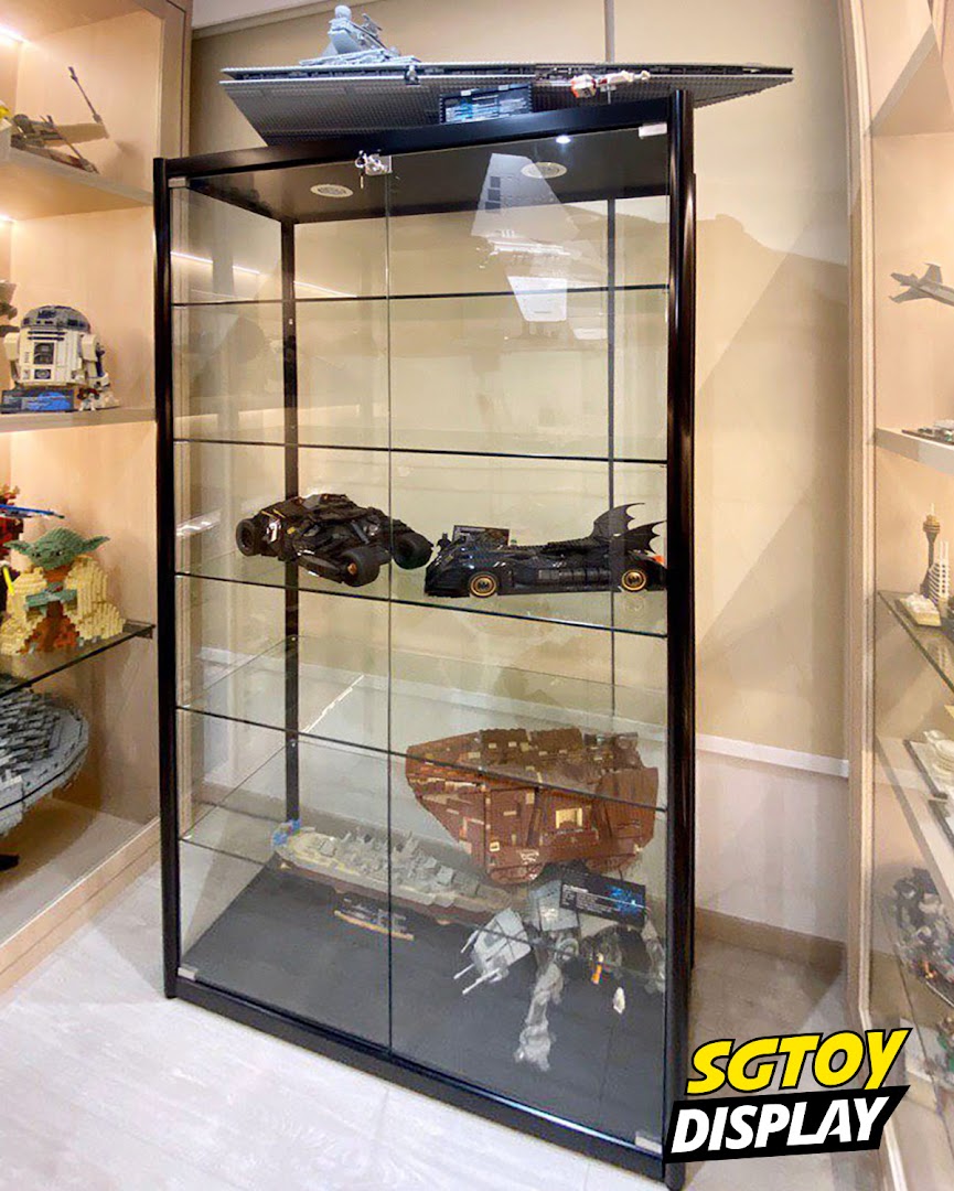 A glass display case showcasing intricate toy models, including Star Wars and Batman vehicles.