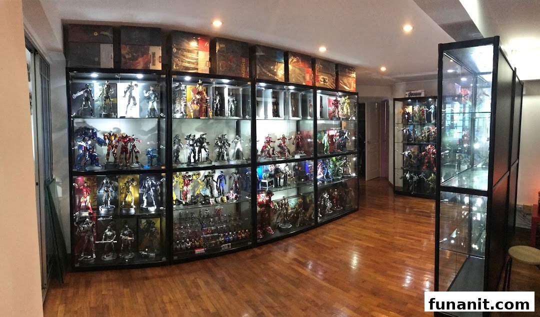 A room showcasing numerous collectible action figures and statues in illuminated glass display cases.