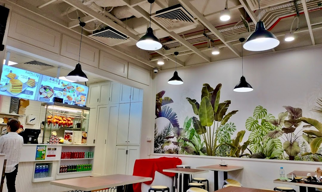 Interior view of Sing Swee Kee, featuring a counter, seating area, and a digital menu board.