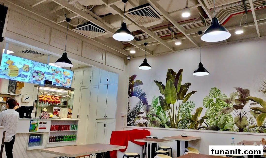 Interior view of Sing Swee Kee, featuring a counter, seating area, and a digital menu board.