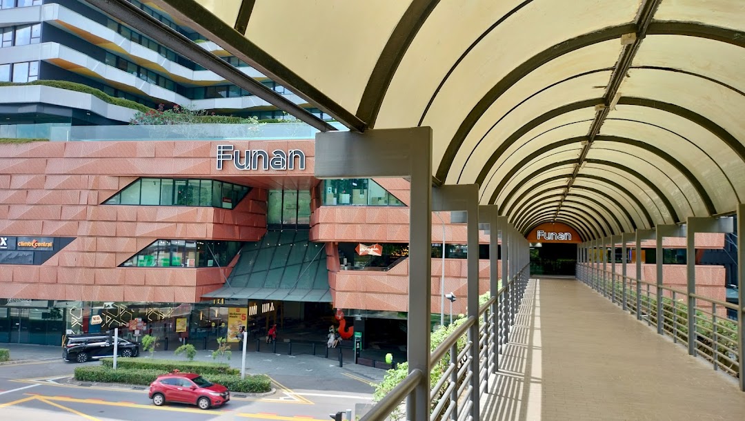 Exterior view of Funan mall with its distinctive architecture and an overhead pedestrian bridge.