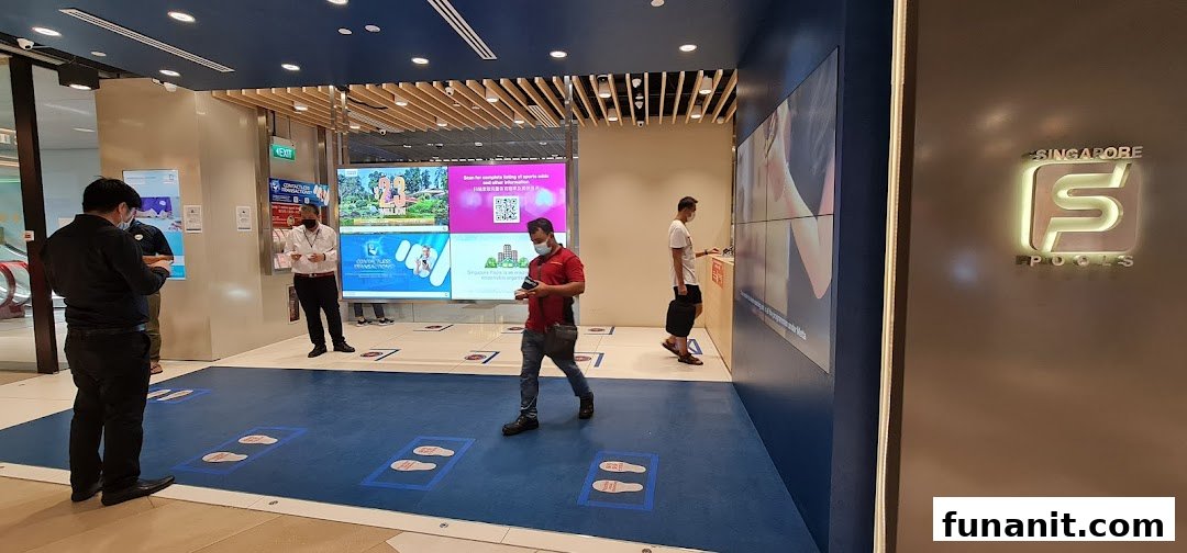 The entrance of Singapore Pools Funan Branch with customers, staff, and digital information displays.