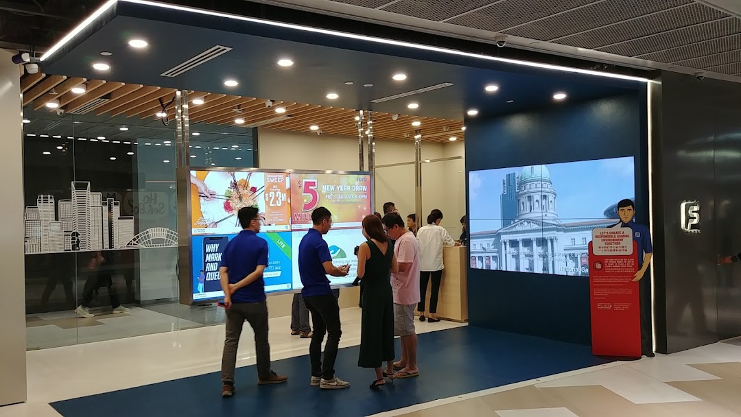 Customers engage with digital displays at the modern Singapore Pools Funan branch entrance.