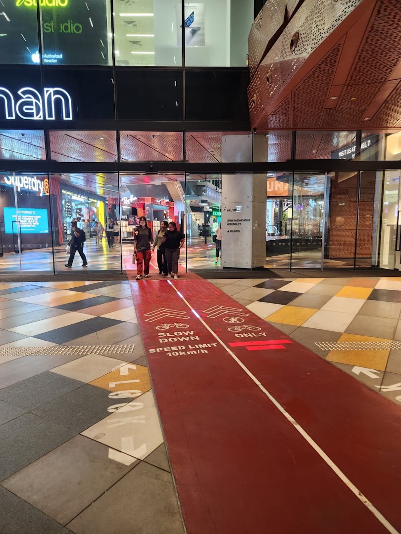 The vibrant entrance of Funan mall featuring a unique indoor cycling path and various retail outlets.