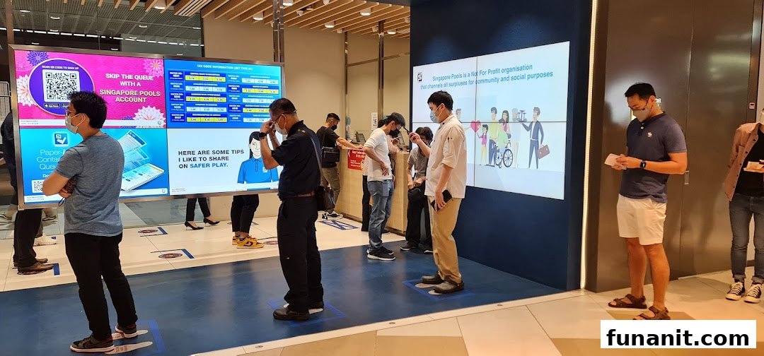 Customers queue at Singapore Pools Funan, viewing digital displays with information and safer play tips.