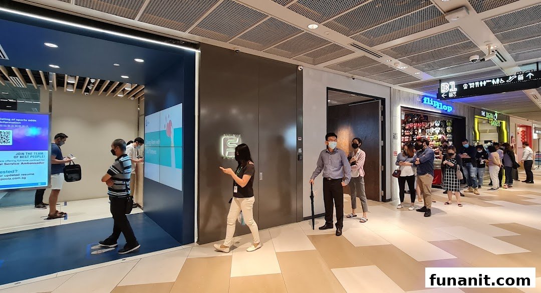 Customers queue outside the modern Singapore Pools Funan branch, featuring digital displays and a sleek entrance.