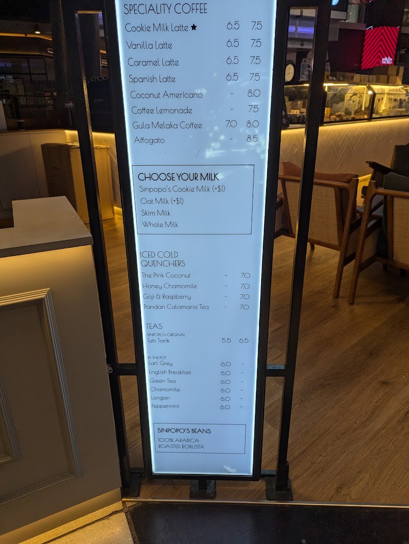A brightly lit menu board displaying coffee, tea, and beverage options at Sinpopo Coffee.