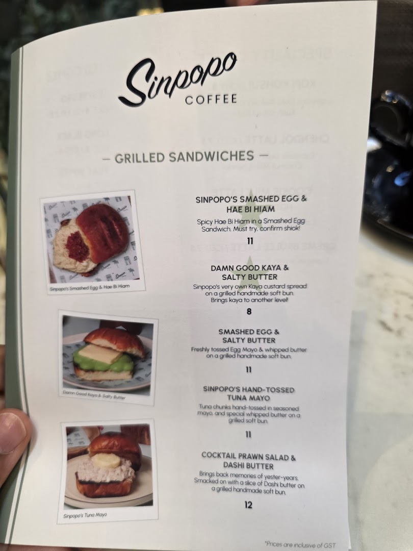 A close-up of Sinpopo Coffee's menu, featuring their 'Grilled Sandwiches' section with item names, descriptions, and prices.