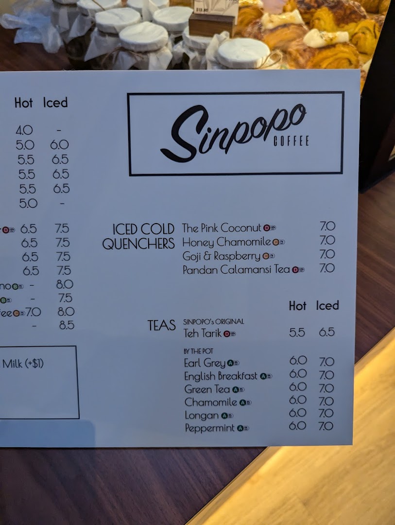A close-up view of Sinpopo Coffee's beverage menu, featuring hot, iced, quenchers, and teas.
