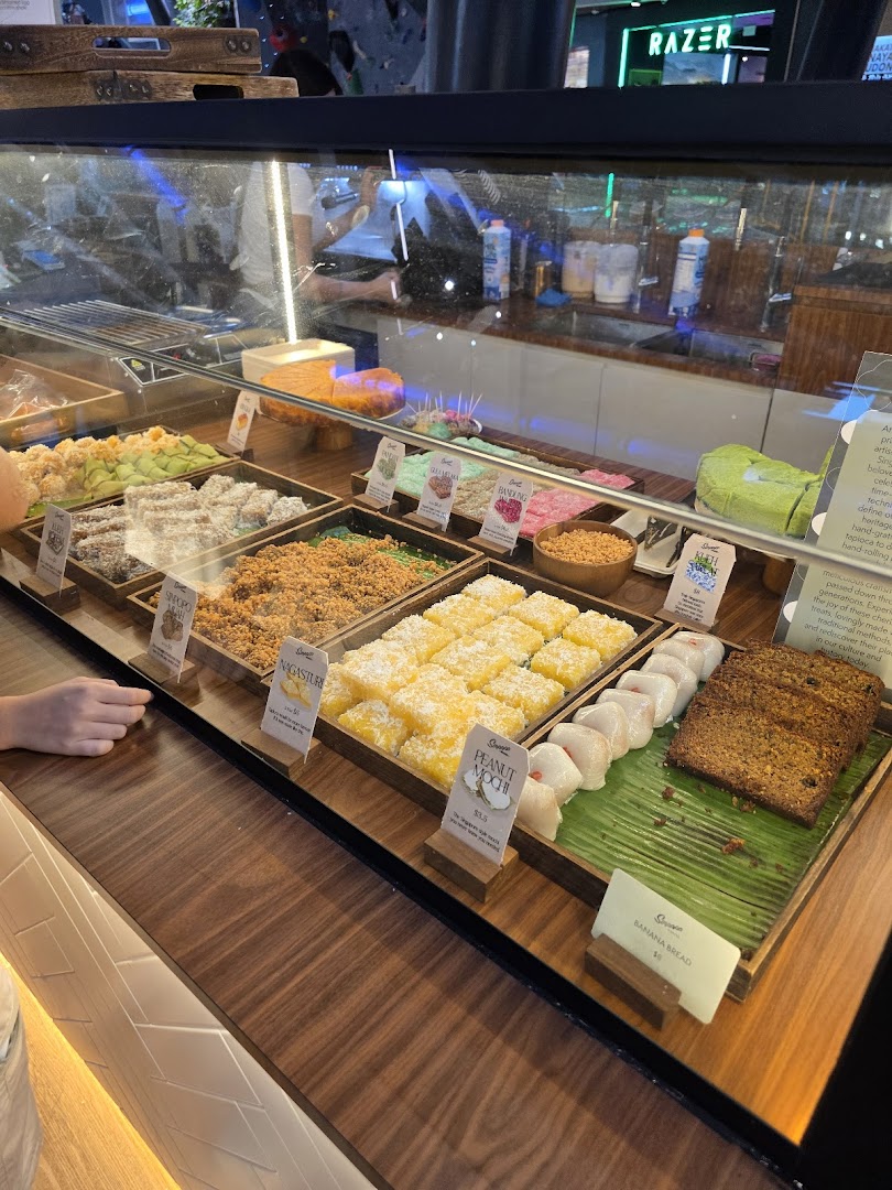 A vibrant display counter showcasing an assortment of traditional Singaporean desserts and pastries.