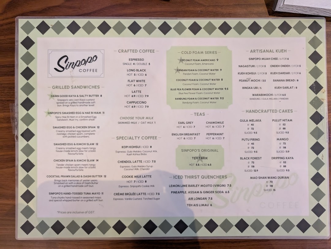 A detailed menu from Sinpopo Coffee, showcasing a variety of coffees, teas, sandwiches, kueh, and cakes.