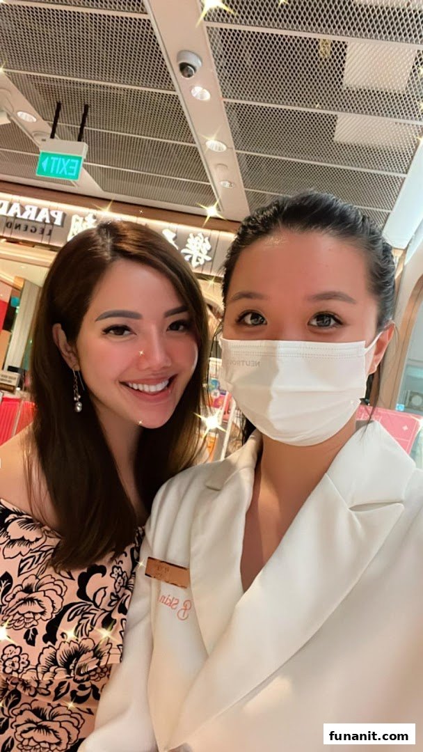 Two women, one smiling and one masked, posing inside the Skin Belief shop.