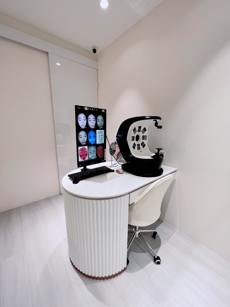 A modern skin analysis station with a monitor displaying facial scans and a diagnostic machine.
