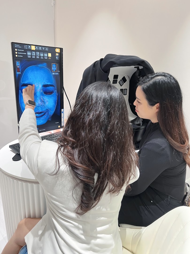 A Skin Belief staff member explains a detailed skin analysis report to a customer.
