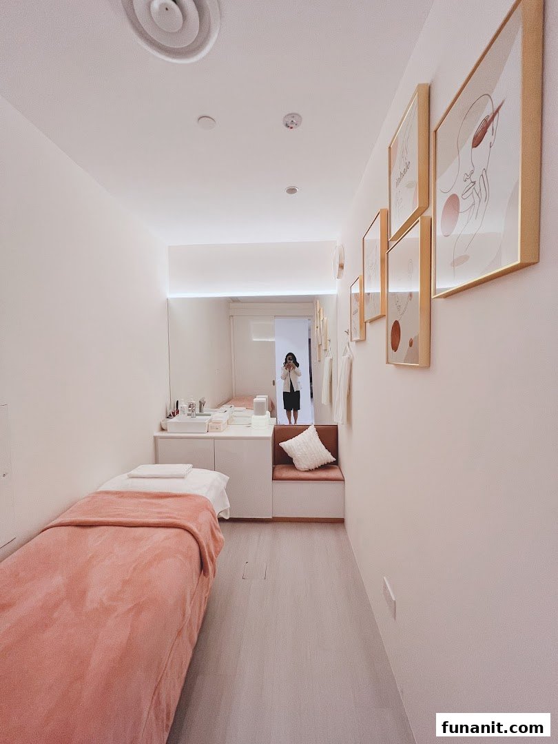 A clean, modern treatment room with a bed, vanity, and minimalist decor.