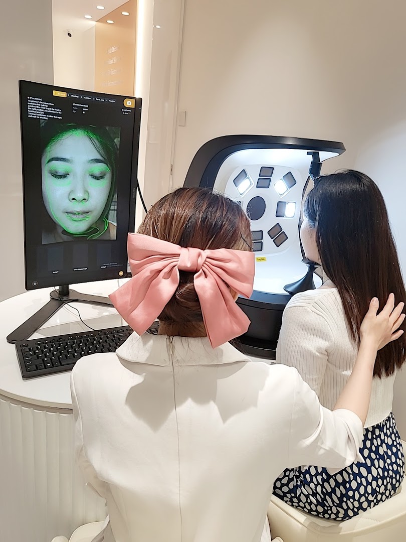 Two women engaged in a skin analysis session at Skin Belief, showcasing advanced skincare technology.