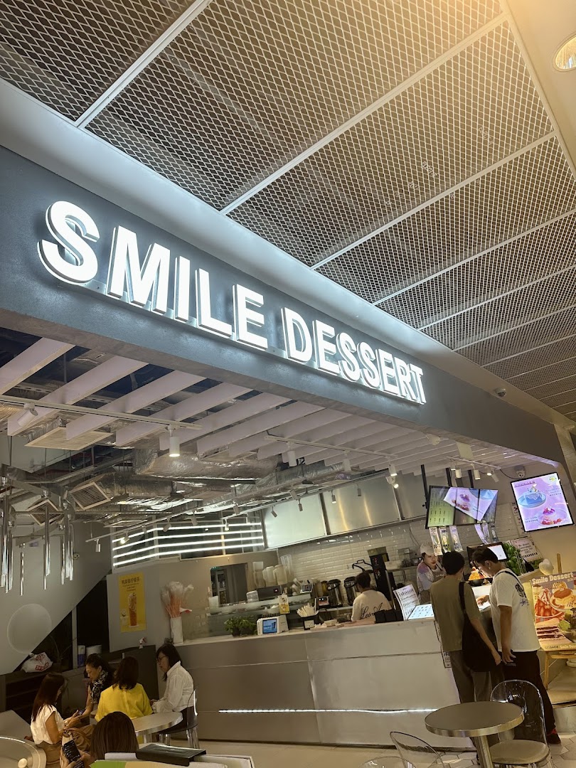 Interior view of Smile Dessert, showcasing its illuminated sign, service counter, and customers.