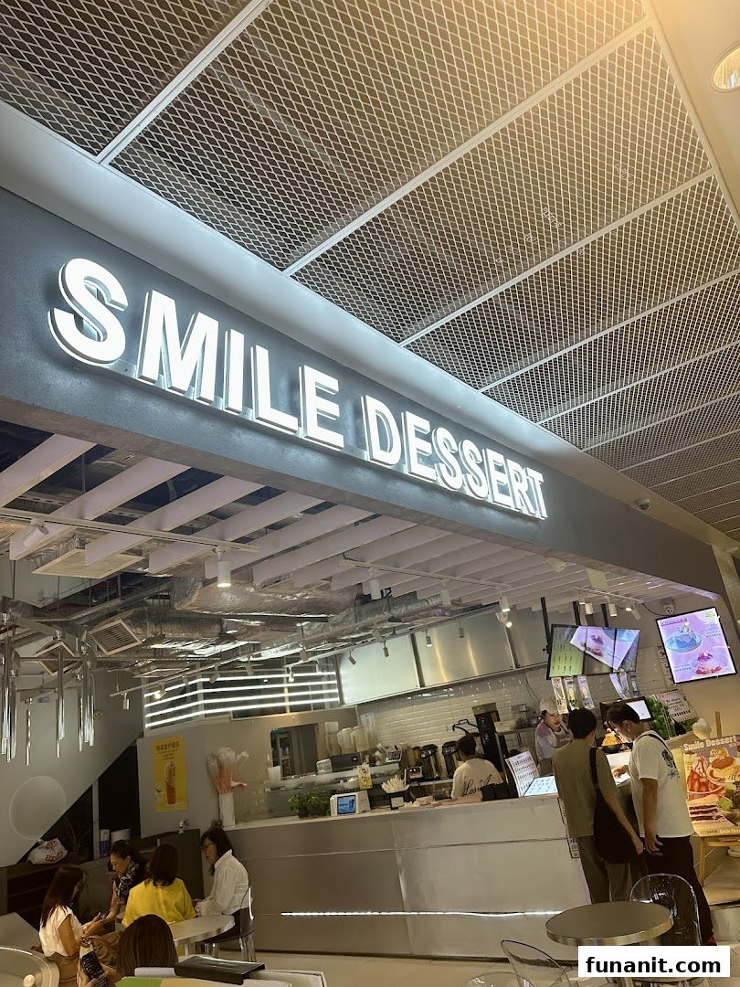 Interior view of Smile Dessert, showcasing its illuminated sign, service counter, and customers.