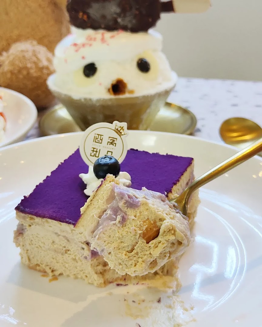 A close-up of a purple-topped dessert being eaten, with a cute character dessert in the background.