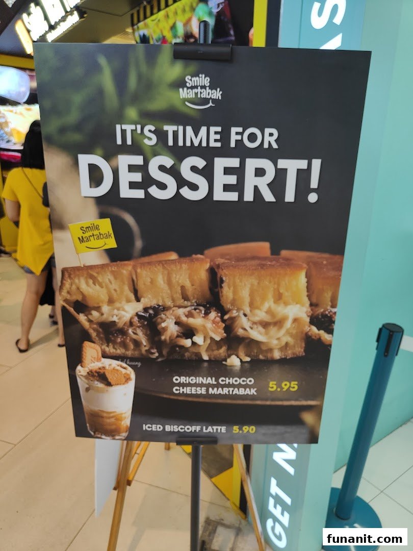 A promotional standee for Smile Martabak showcasing their Original Choco Cheese Martabak and Iced Biscoff Latte.