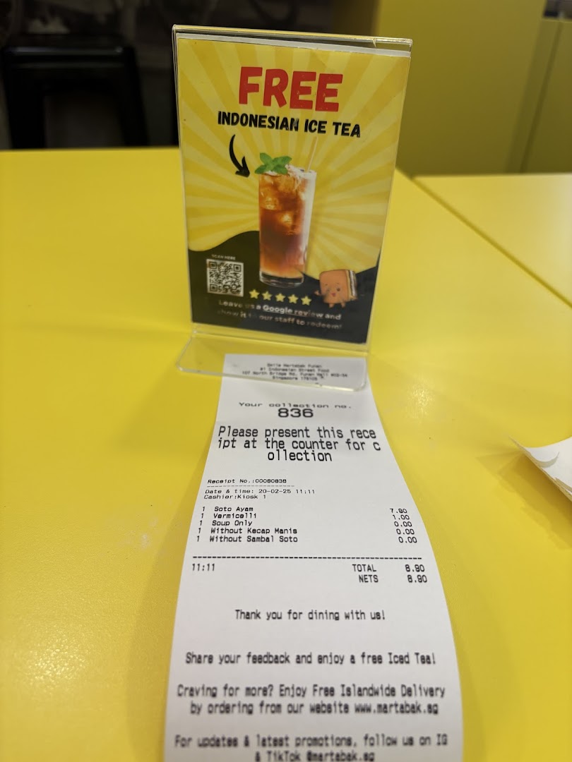 A promotional stand offering free Indonesian Ice Tea for Google reviews, displayed next to a customer receipt.