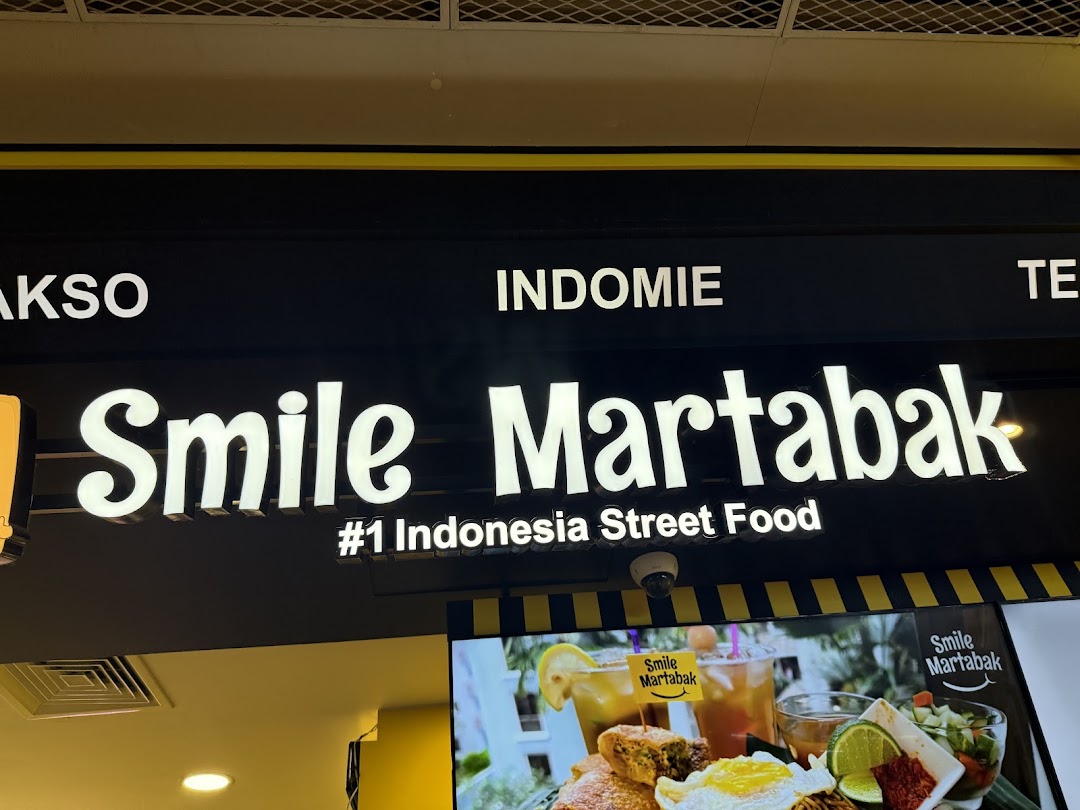 The image displays the illuminated 'Smile Martabak' sign, promoting '#1 Indonesia Street Food' with a vibrant food display below.
