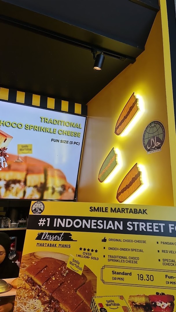 A vibrant display board at Smile Martabak showcasing their popular Indonesian desserts and pricing.
