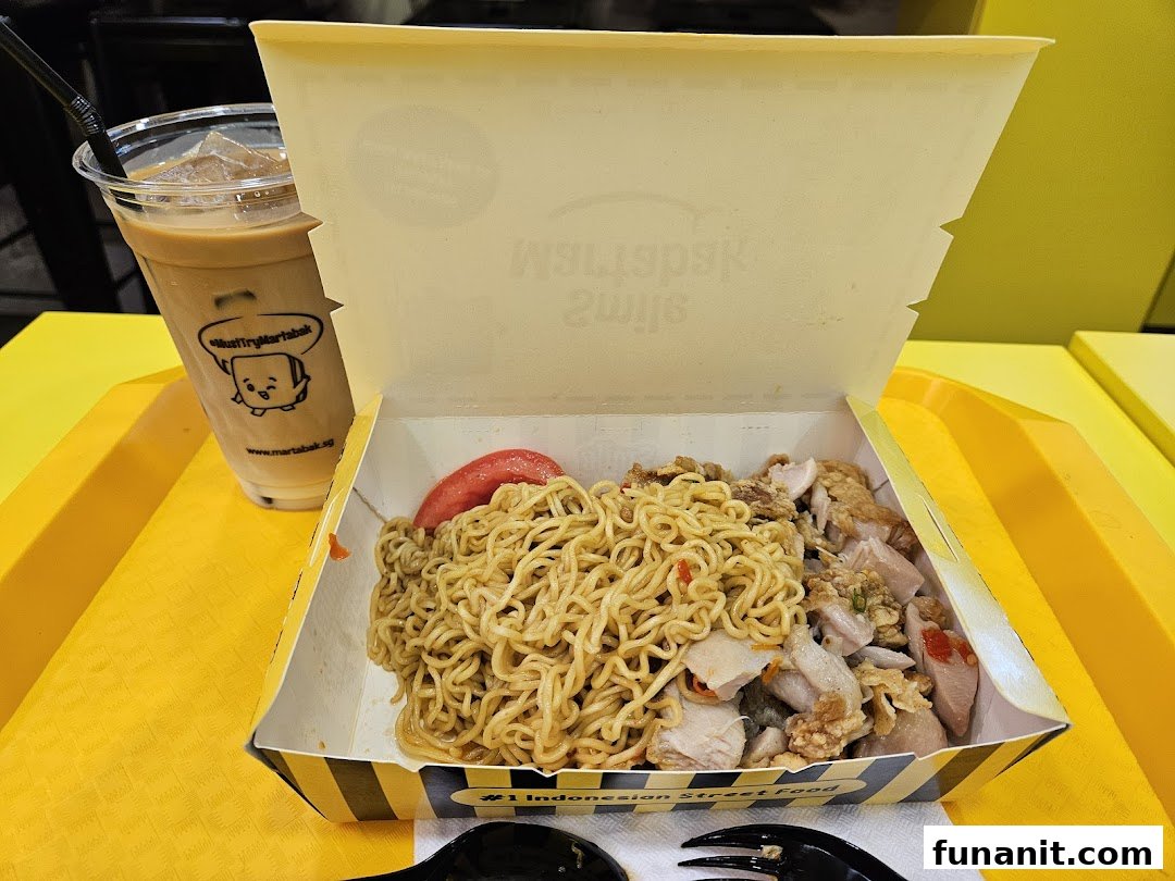 A delicious box of Indonesian street food noodles with chicken and an iced drink from Smile Martabak.