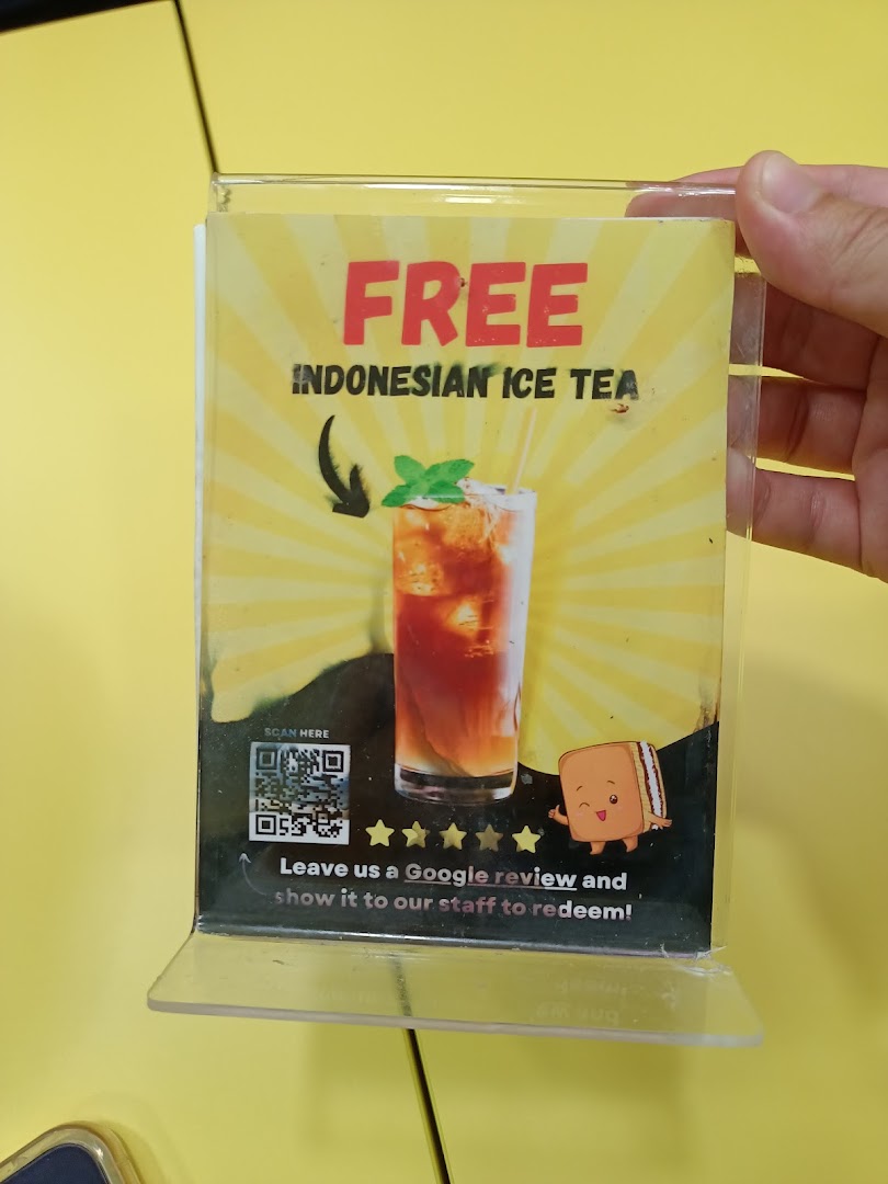 A promotional sign offering free Indonesian Ice Tea for a Google review at Smile Martabak.