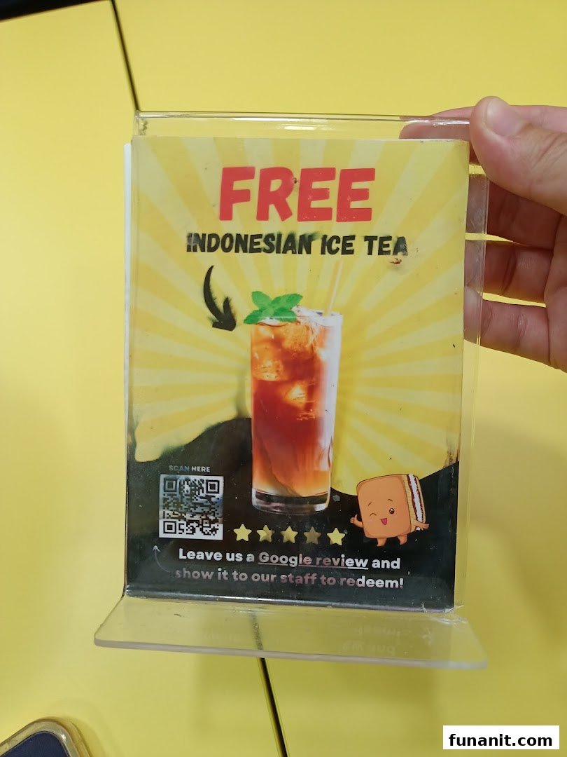 A promotional sign offering free Indonesian Ice Tea for a Google review at Smile Martabak.