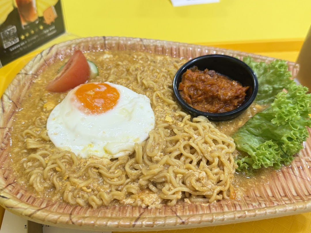 A close-up of delicious noodles topped with a fried egg, chili, and fresh lettuce.