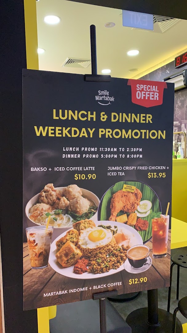 A promotional stand displaying Smile Martabak's weekday lunch and dinner promotions with food images.