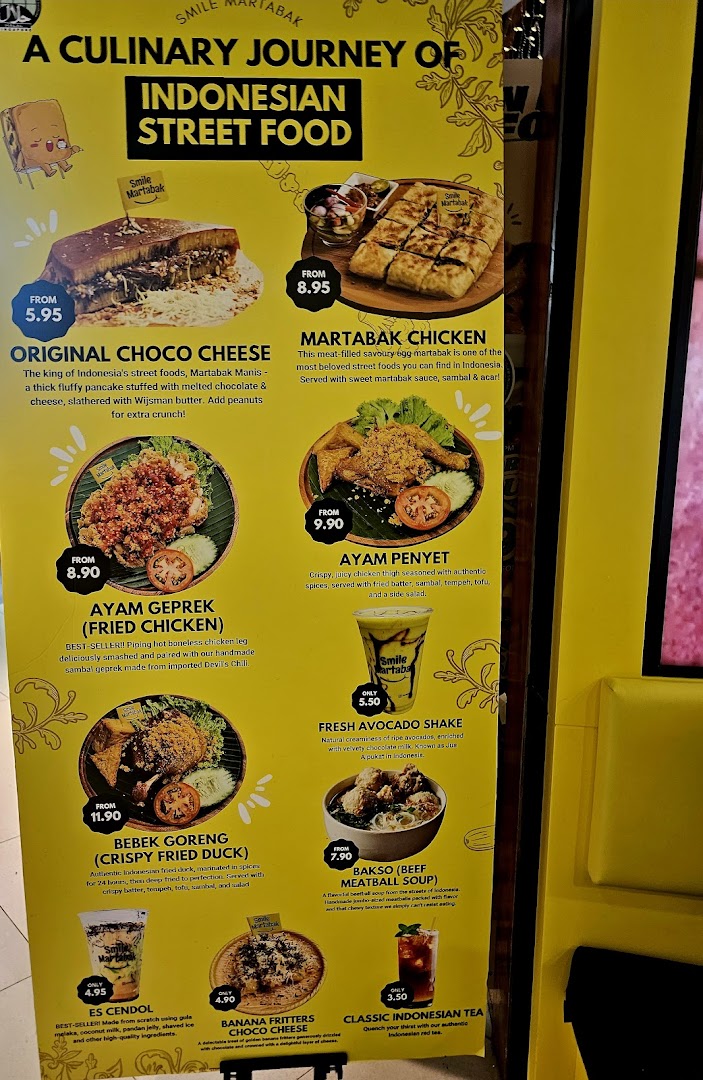 A vibrant yellow menu board showcasing Indonesian street food dishes and drinks from Smile Martabak.