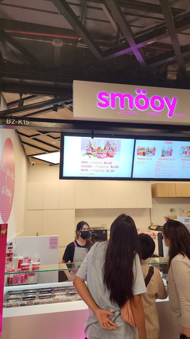 Digital menu boards at smöoy displaying frozen yogurt sizes, prices, and other beverage options.