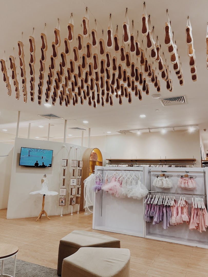 Interior of Sonata Flagship Store featuring ballet shoes on the ceiling, dancewear, and a tutu mannequin.